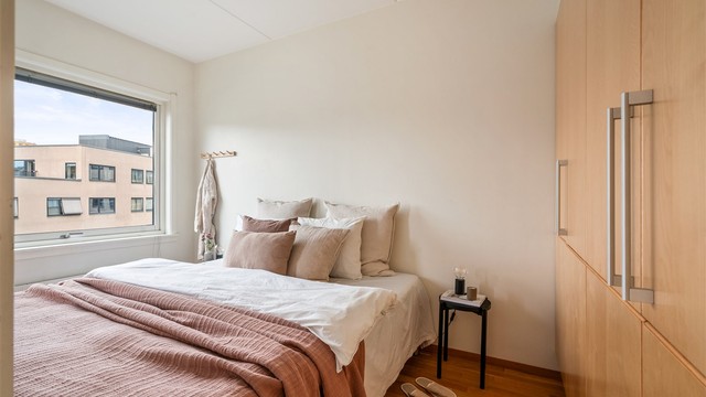 Romslig og trivelig soverom med god plass til dobbeltseng og tilhørende nattbord.