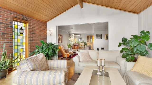 Stuen er delt inn i flere soner, med en åpen løsning mellom den opprinnelige delen og tilbygget.