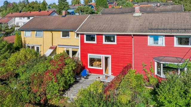 Rekkehus med en solrik, sydvestvendt terrasse og en pent opparbeidet hage på begge sider av boligen. Foto: Per Oscar Skjellnan v/Efkt