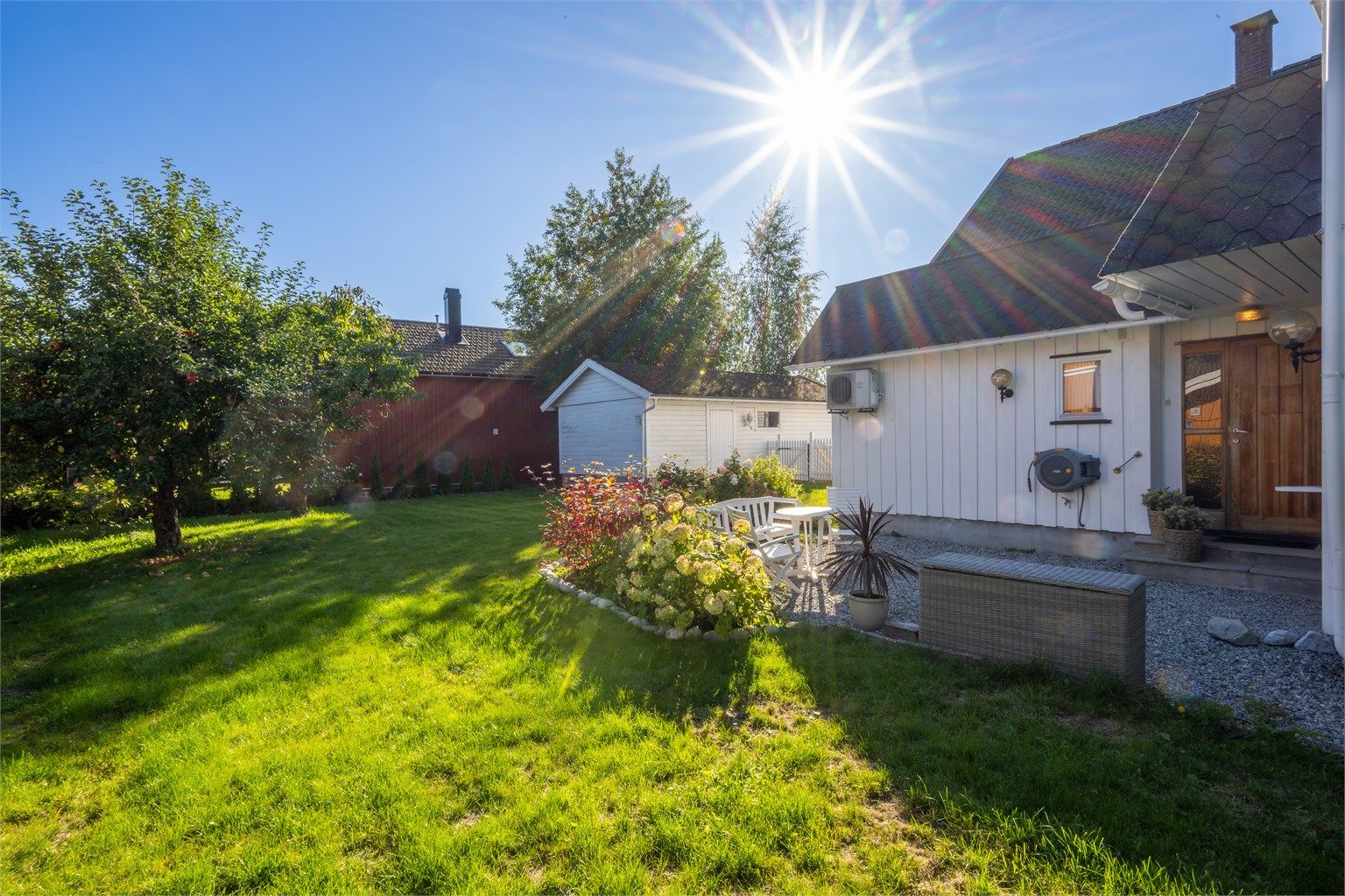 Hagen har et koselig og lunt plenområde, bed og busker og trær som skjermer mot naboer.