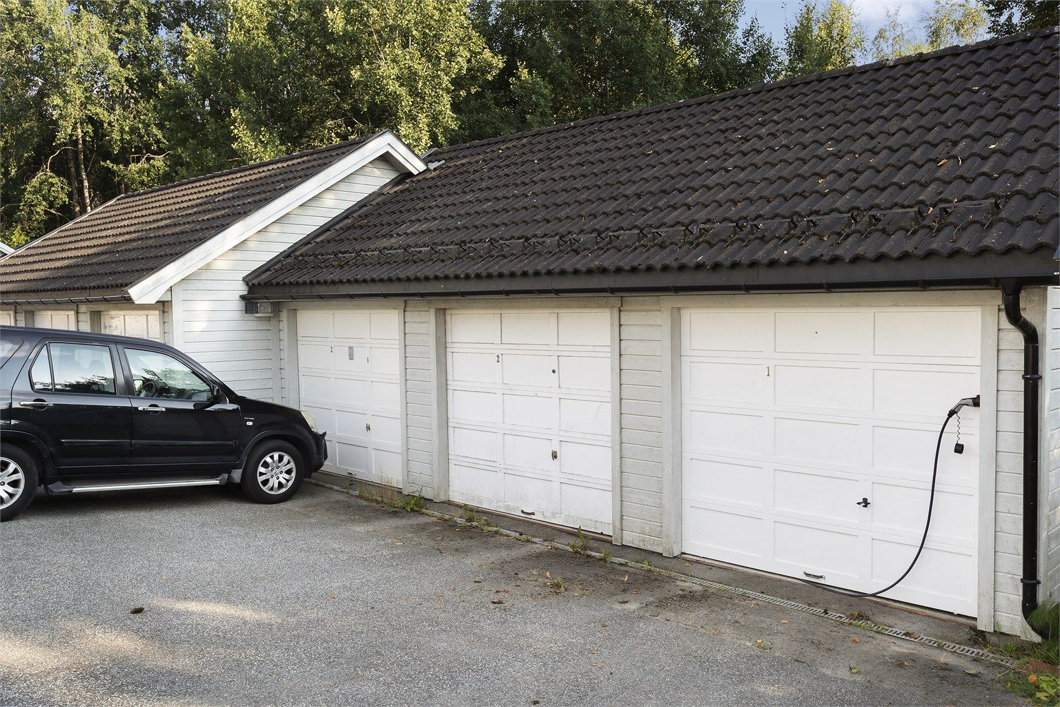 Garasjeplass i felles rekke, med elektrisk leddport og elbil-lader.