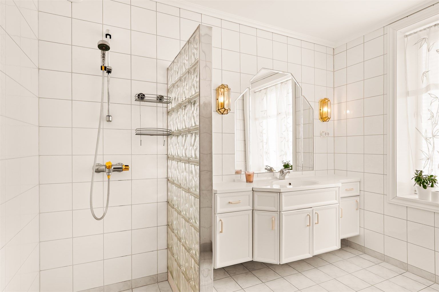 Hovedbadet er flislagt og utstyrt med gulvvarme, dusj med glassbyggervegg og en stor servantinnredning.