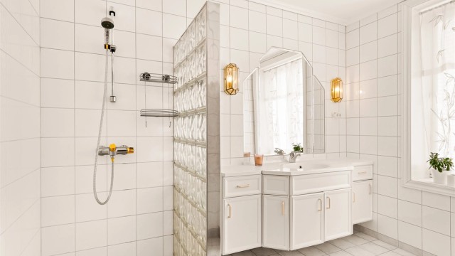 Hovedbadet er flislagt og utstyrt med gulvvarme, dusj med glassbyggervegg og en stor servantinnredning.