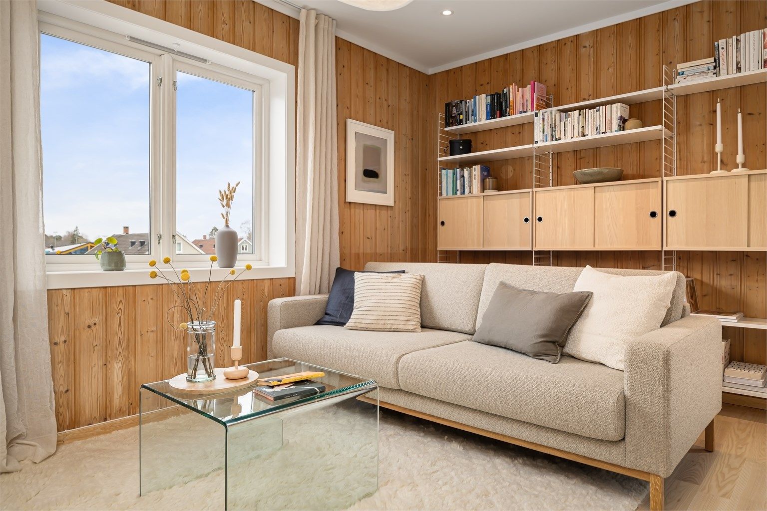 Veggflatene er kledd i koselig, stående panel og på gulvet er det nyslipt parkett i ask