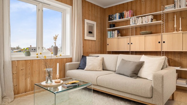 Veggflatene er kledd i koselig, stående panel og på gulvet er det nyslipt parkett i ask