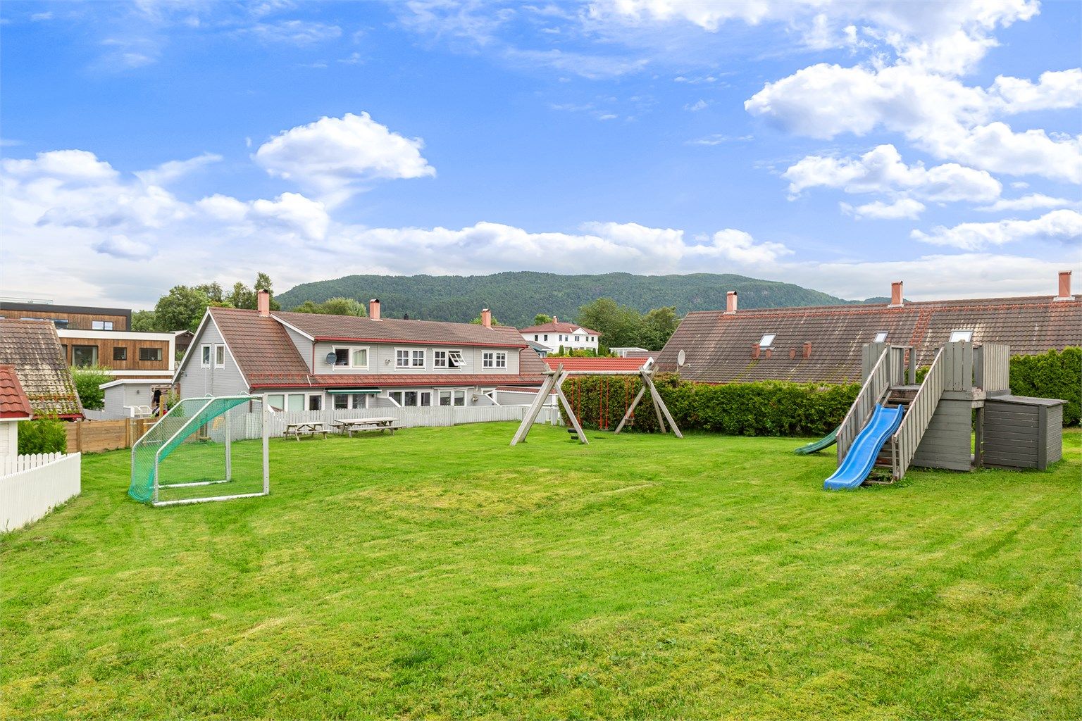 Det er også et felles lekeområde med gressplen, fotballmål og lekeapparater i nærheten av rekkehuset.