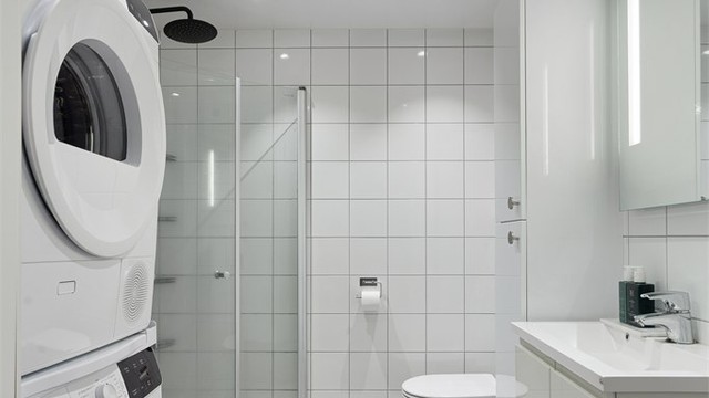 Flislagt bad med gulvvarme og downlights i himlingen. Innredet med vegghengt servantskap med nedfelt servant. Opplegg for vaskemaskin.