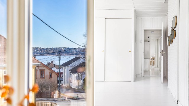 Plassbygget skyvedørsgarderobe inngår i det største soverommet/loftstuen. Gjennom vinduet langstrakt utsikt og gløtt av sjøen i Mossesundet.