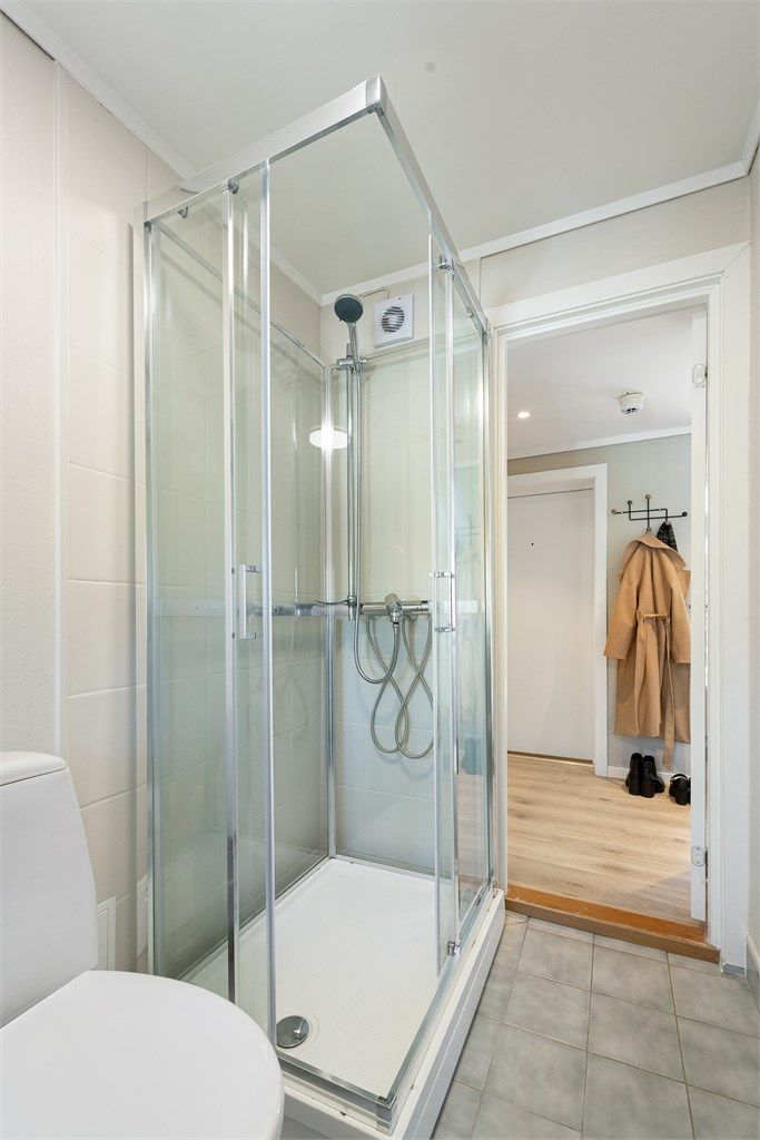 Badet er utstyrt med dusjkabinett og gulvstående toalett.