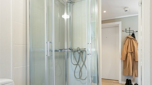 Badet er utstyrt med dusjkabinett og gulvstående toalett.