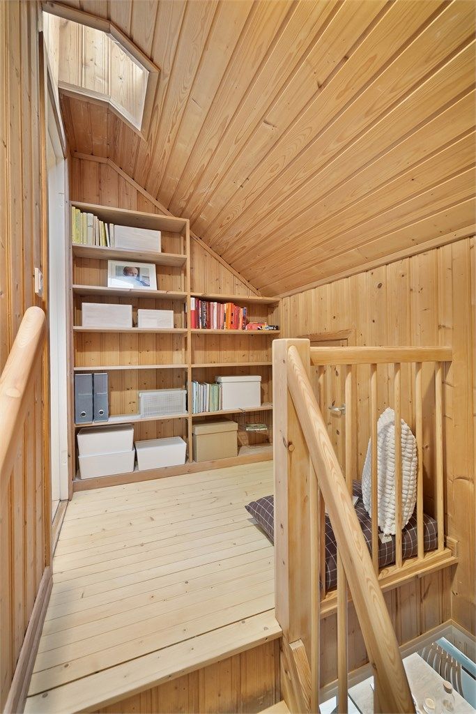 Trappen i stuen leder deg opp til tredje etasje, med en romslig hylleløsning på trappeavsatsen