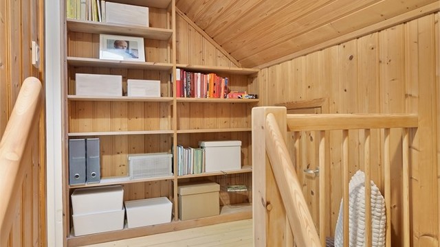 Trappen i stuen leder deg opp til tredje etasje, med en romslig hylleløsning på trappeavsatsen