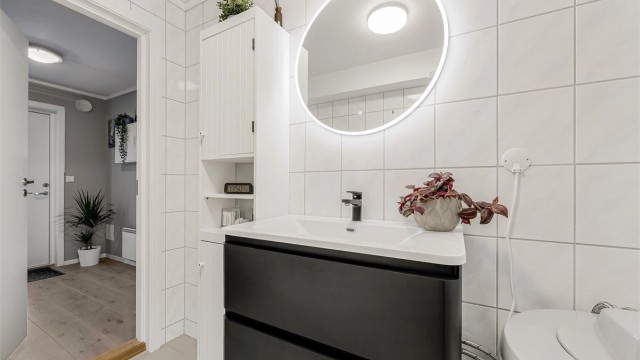 Flislagt bad med gulvvarme og vegghengt servantinnredning.