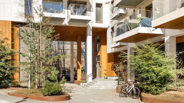 Pent opparbeidede fellesarealer med sykkelparkering og en innbydende inngang.