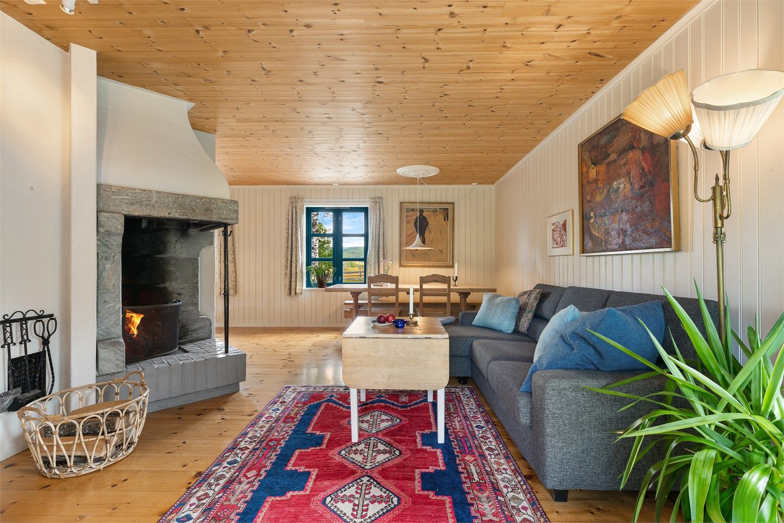 Stue og spiseplass i åpen løsning med godt lysinnslipp og utsikt.