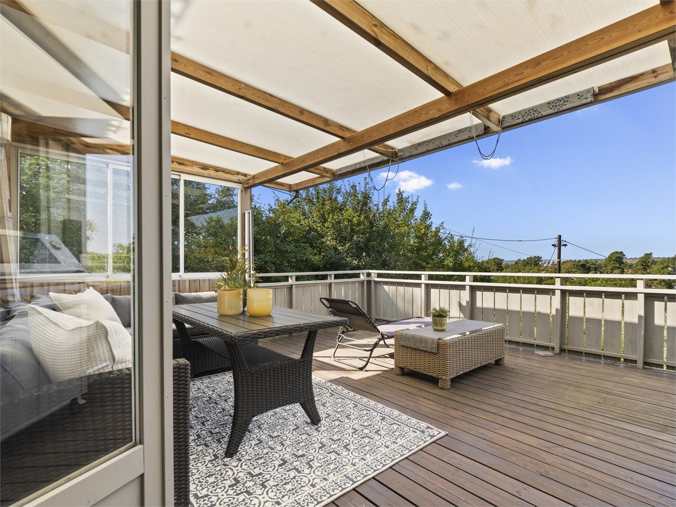 Skjermende overbygg, glass og uttrekkbar duk utvider balkongens bruksmuligheter.