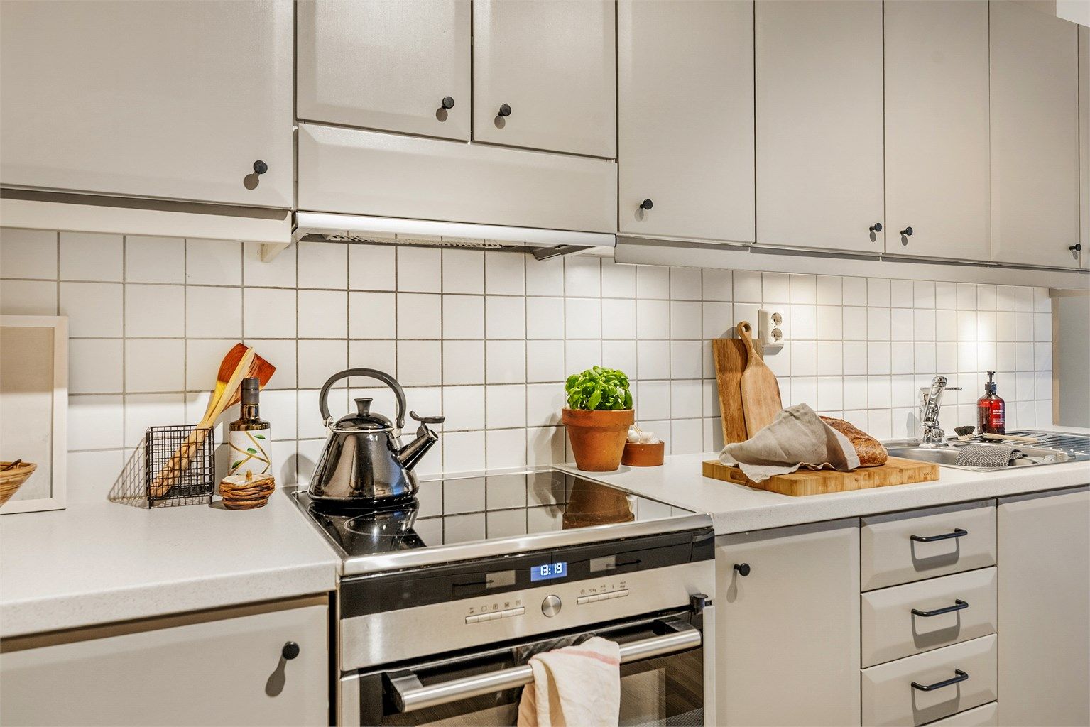 Belysning er montert under kjøkkenskap, samt fliser og stikkontakter