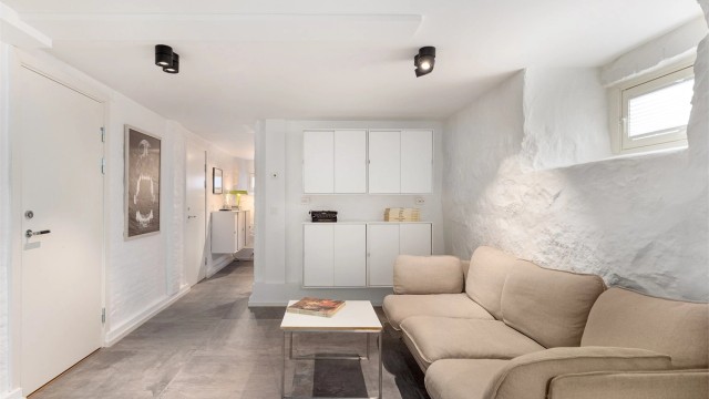 Det er idag innredet som en ys og moderne kjellerstue. Men det er lagt klart for vann i veggen der skapene henger om man skulle ønske å etablere et kjøkken