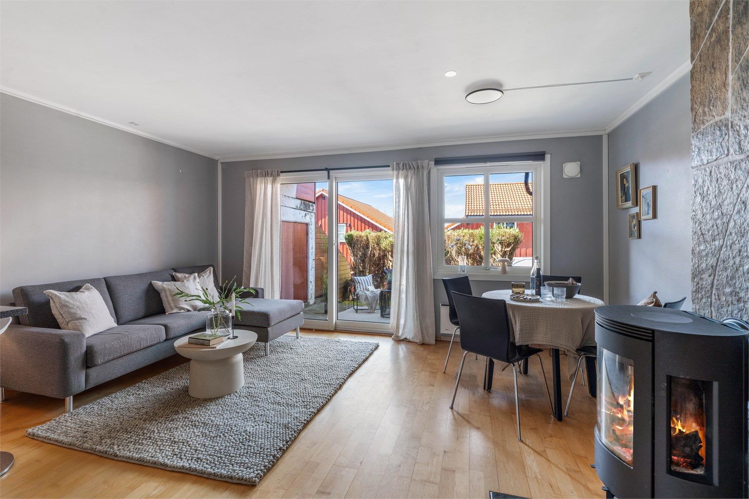 Ildstedet fra cirka 2020, med pipevanger kledd i naturstein, gir en lun atmosfære og effektiv tilleggsvarme.