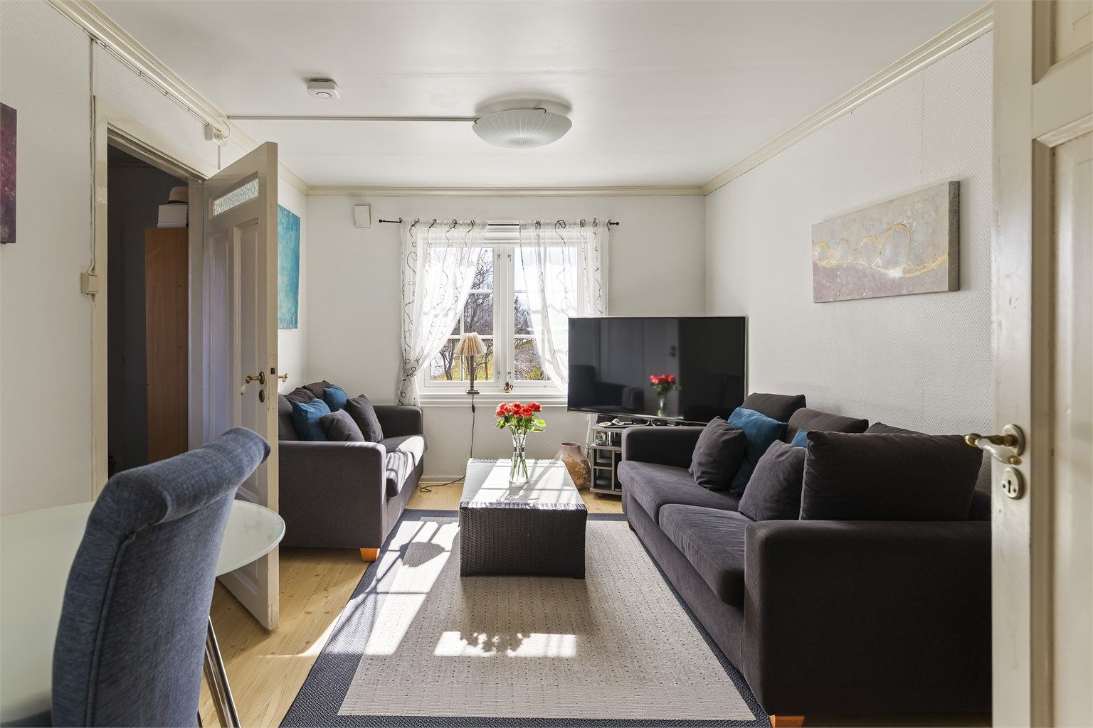 Stuen i utleiedelen har laminat på gulvet og plass til en sofagruppe.