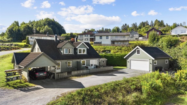 Innholdsrik halvpart av tomannsbolig med usjenert bakhage og nyere dobbelgarasje.