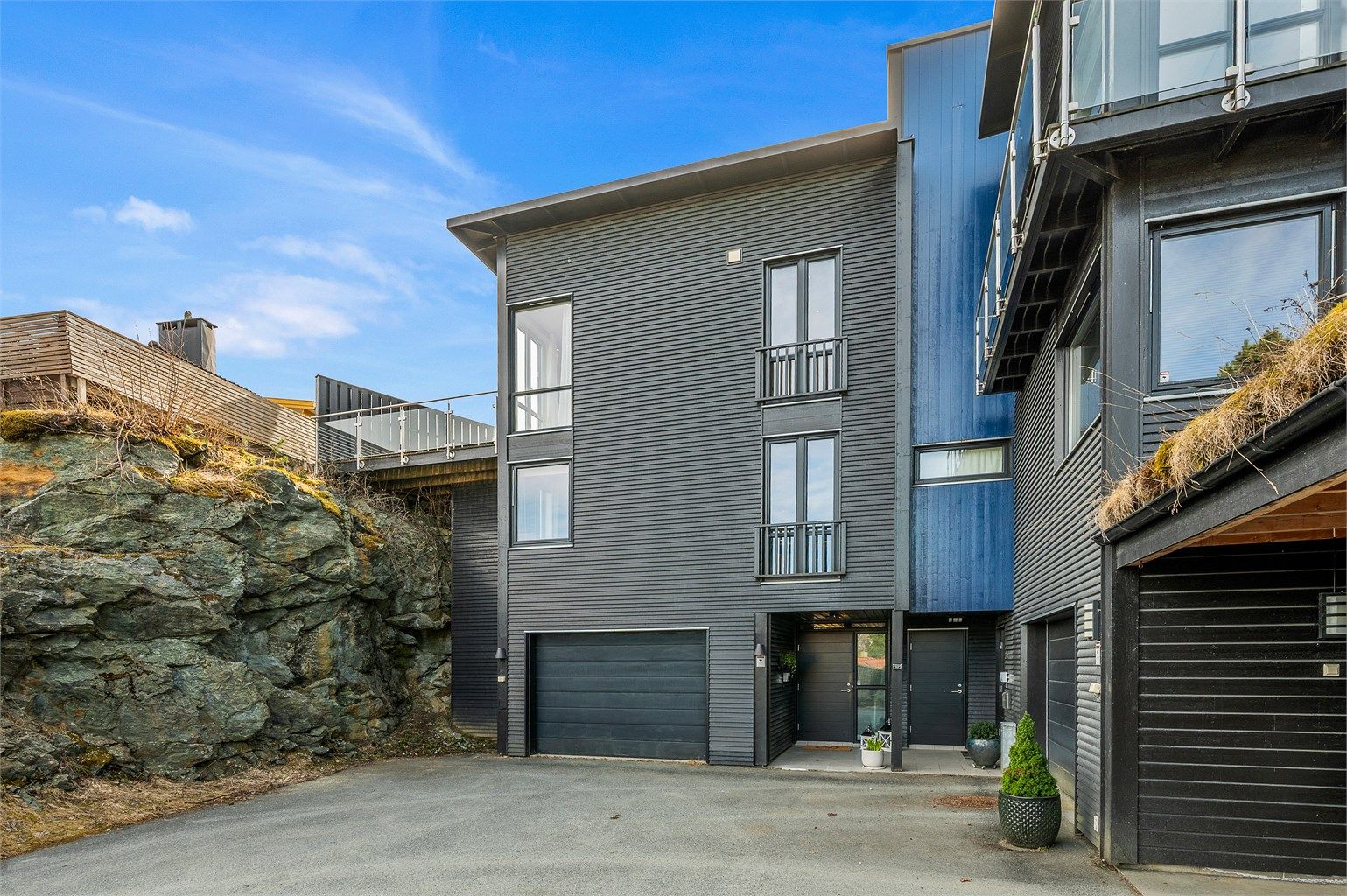 Boligen har en ryddig og innbydende adkomst, med garasje og flere oppstillingsplasser på felles tomt som gjør hverdagen enkel.