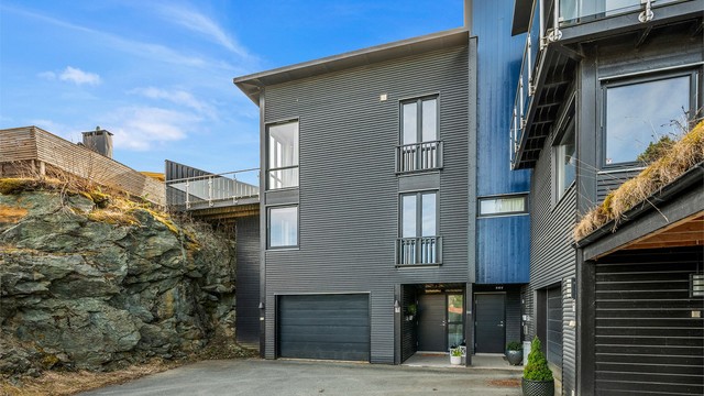 Boligen har en ryddig og innbydende adkomst, med garasje og flere oppstillingsplasser på felles tomt som gjør hverdagen enkel.