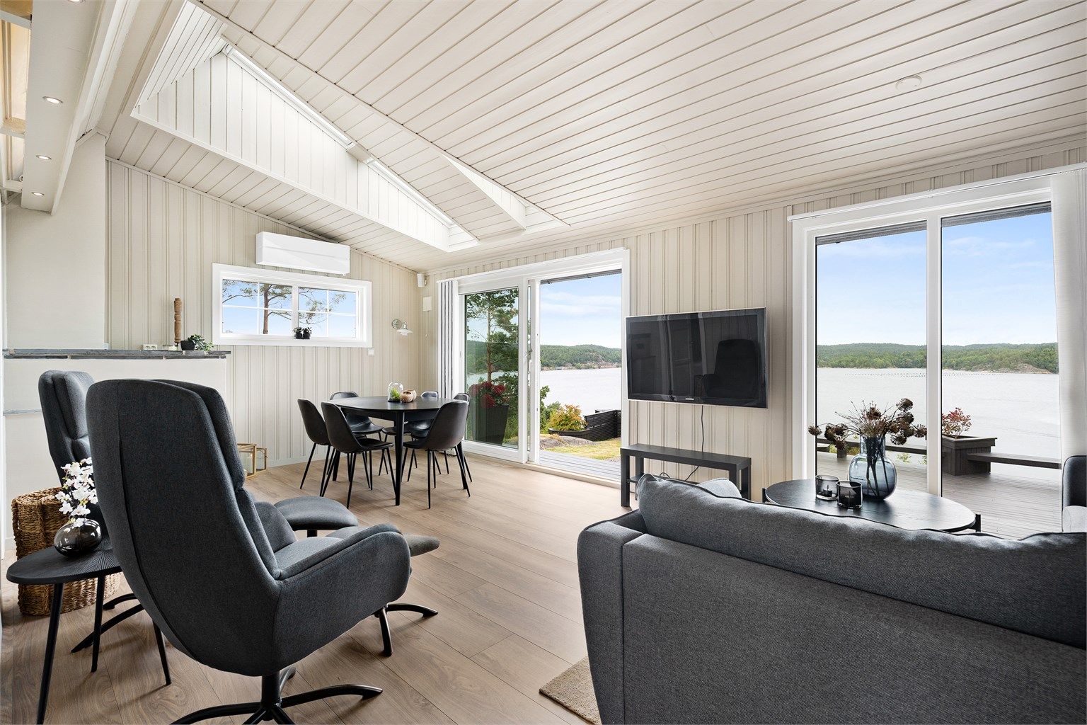 Stuen har gode lysforhold og flott utsikt. Skyvedører ut til hagen og en av terrassene.