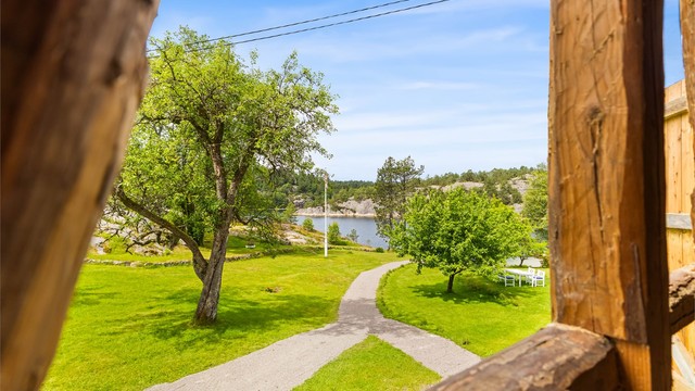 Låven med åpne dører - Vakker utsikt utover hagen og mot vannet