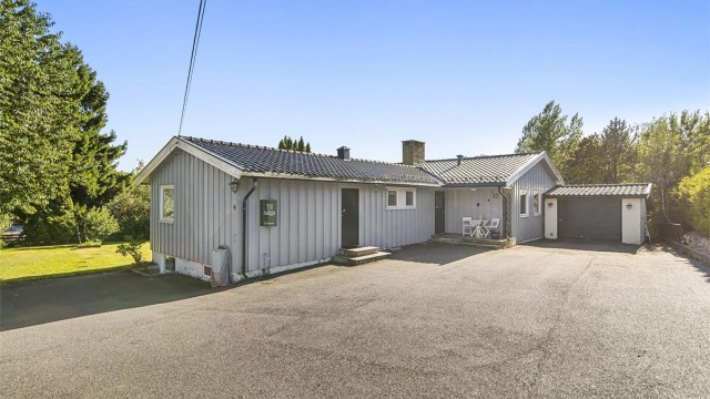 Gårdsplassen er asfaltert og har rikelig med parkeringsplasser - praktisk for både familie og gjester.