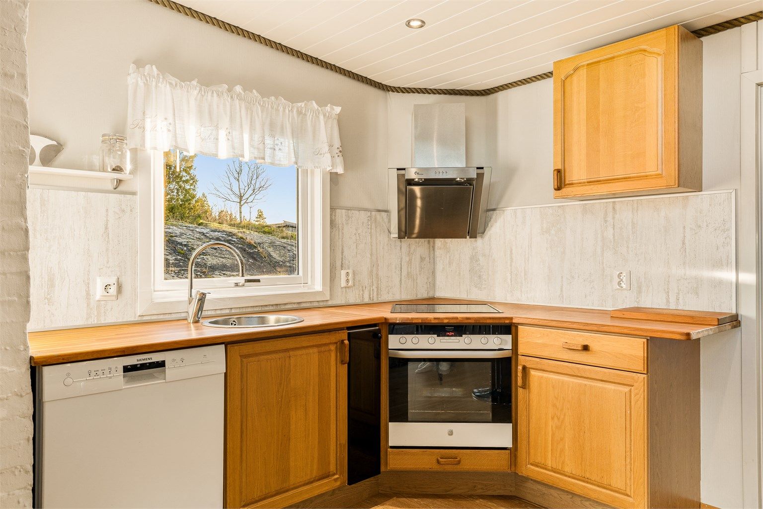 Kjøkkenet er utstyrt med oppvaskmaskin, stekeovn og koketopp.