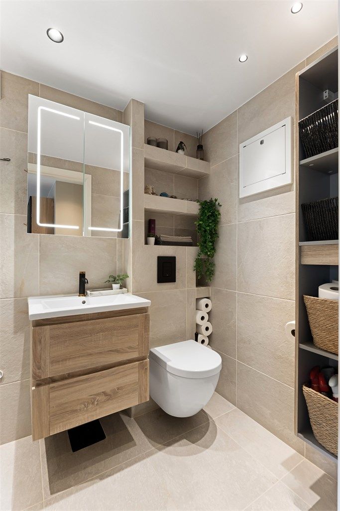 Badet er innredet med vegghengt servantskap med ovenpåliggende servant, speilskap med belysning, dusjsone med innfellbare glassdører, hånddusj og regndusj samt vegghengt toalett