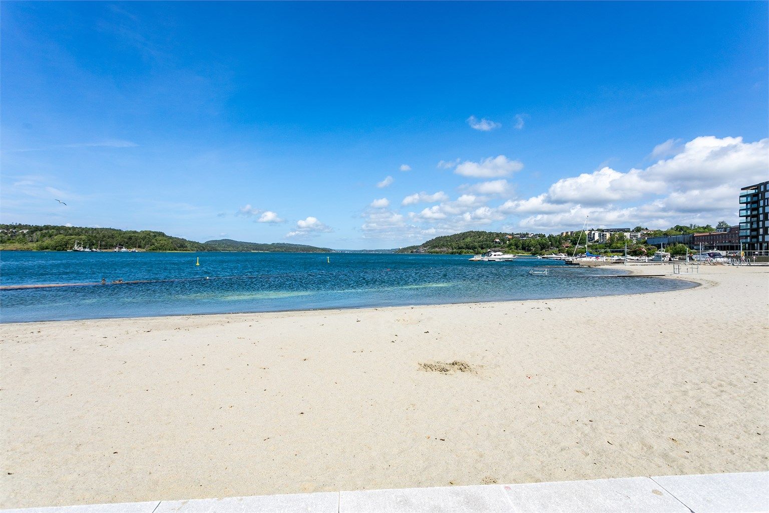 Den nye, store sandstranden ytterst på Verket er et populært sted å bade i sjøen.