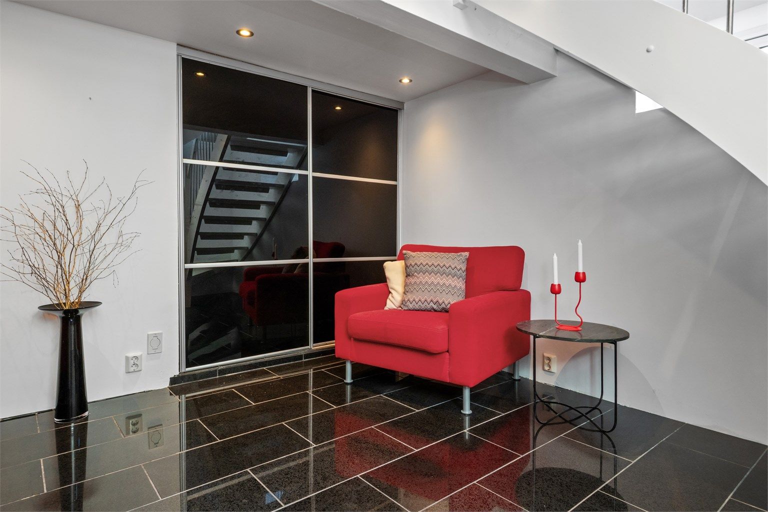 Stuen er innredet med sorte, skyvbare garderobedører i innerste del, som fører inn til en gang med adkomst til bod, vaskerom og toalett. (Ikke godkjent for varig opphold).