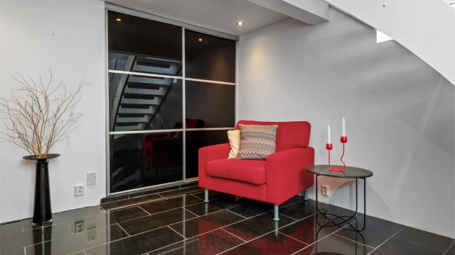 Stuen er innredet med sorte, skyvbare garderobedører i innerste del, som fører inn til en gang med adkomst til bod, vaskerom og toalett. (Ikke godkjent for varig opphold).