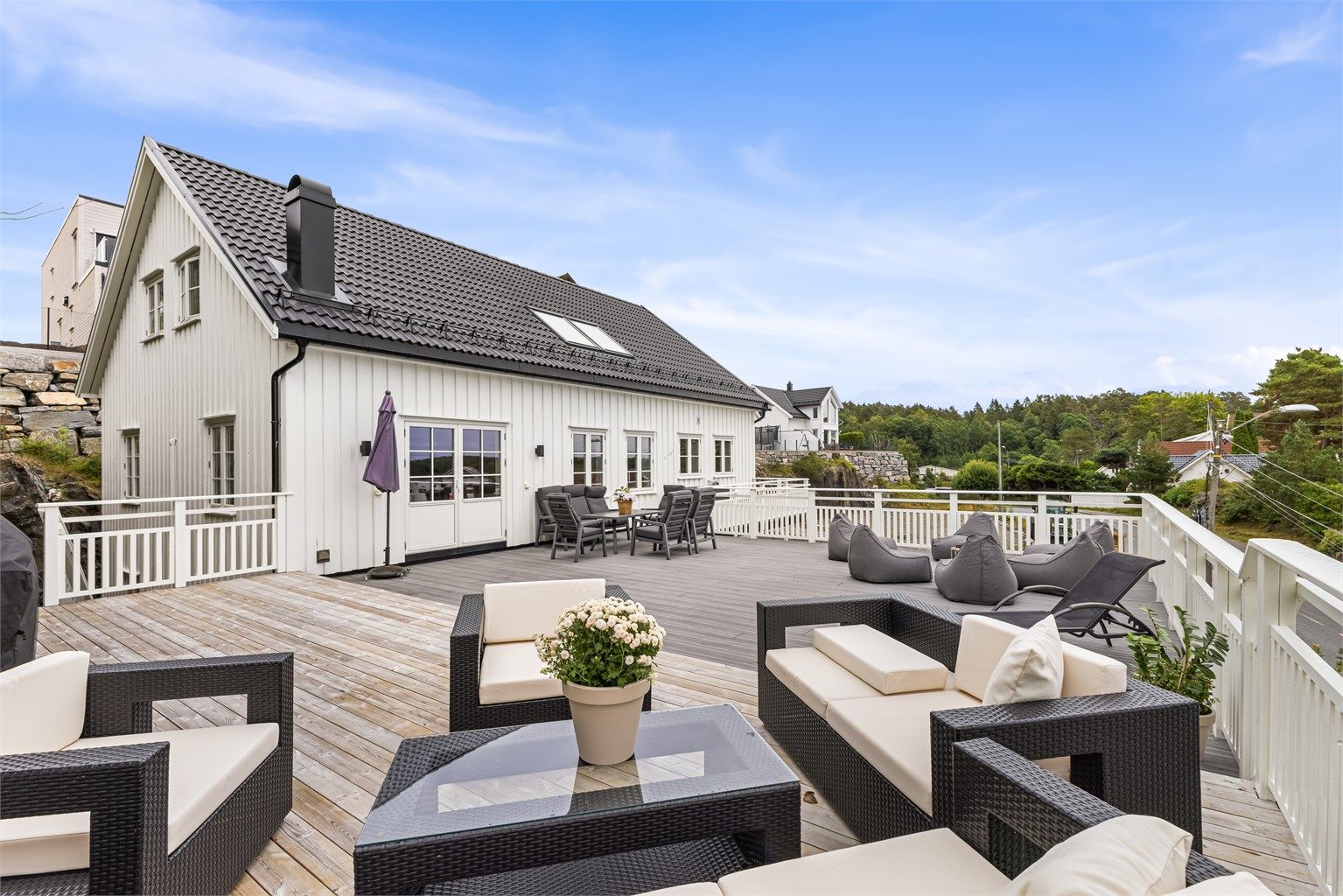 Stor og solrik veranda som innbyr til et rikt liv ute - med rikelig plass både til loungegrupper, spisebord og blomstrende krukker