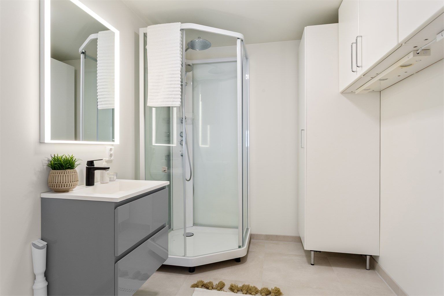 Bad/vaskerom med flislagt gulv med varme fra 2025/26. Malte vegg- og himlingsflater. Nytt speil og ny baderomsinnredning. (ubrukt)  Dusjkabinett, høyskap og vegghengte skap er forholdsvis nytt og lite brukt.  