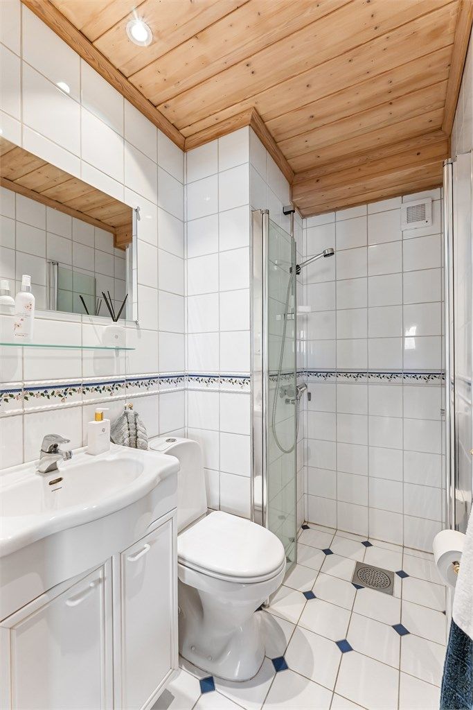 Det andre badet i underetasjen har flislagt gulv med gulvvarme og dusjhjørne.