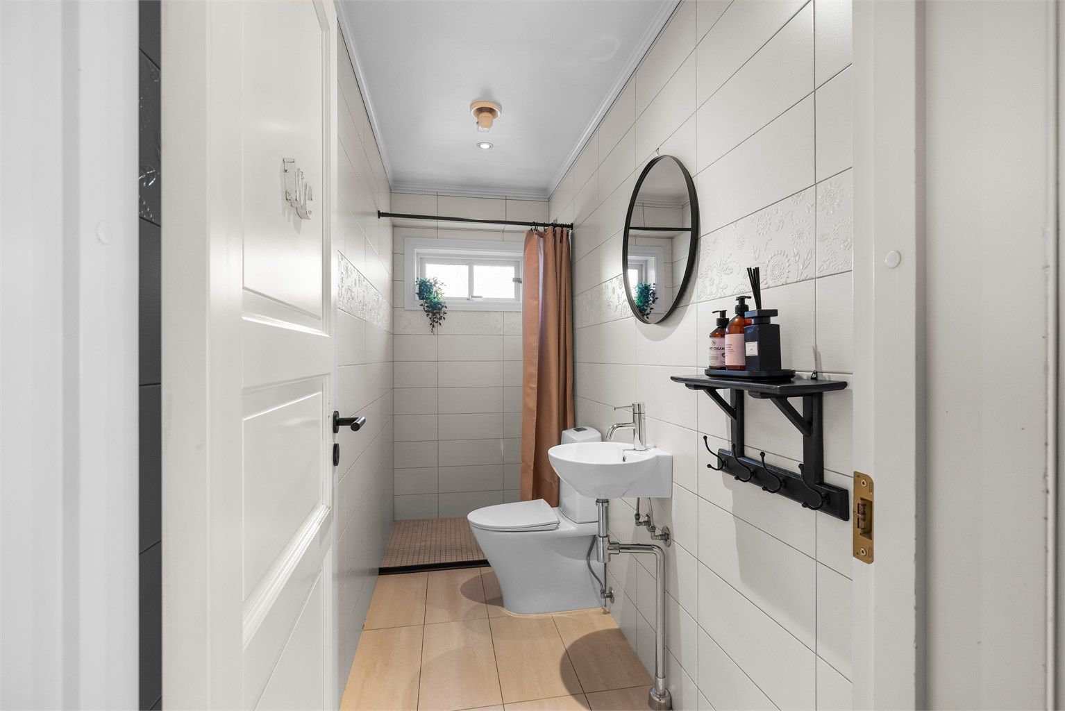 Badet i første etasje har flislagt gulv med gulvvarme og dusjhjørne.