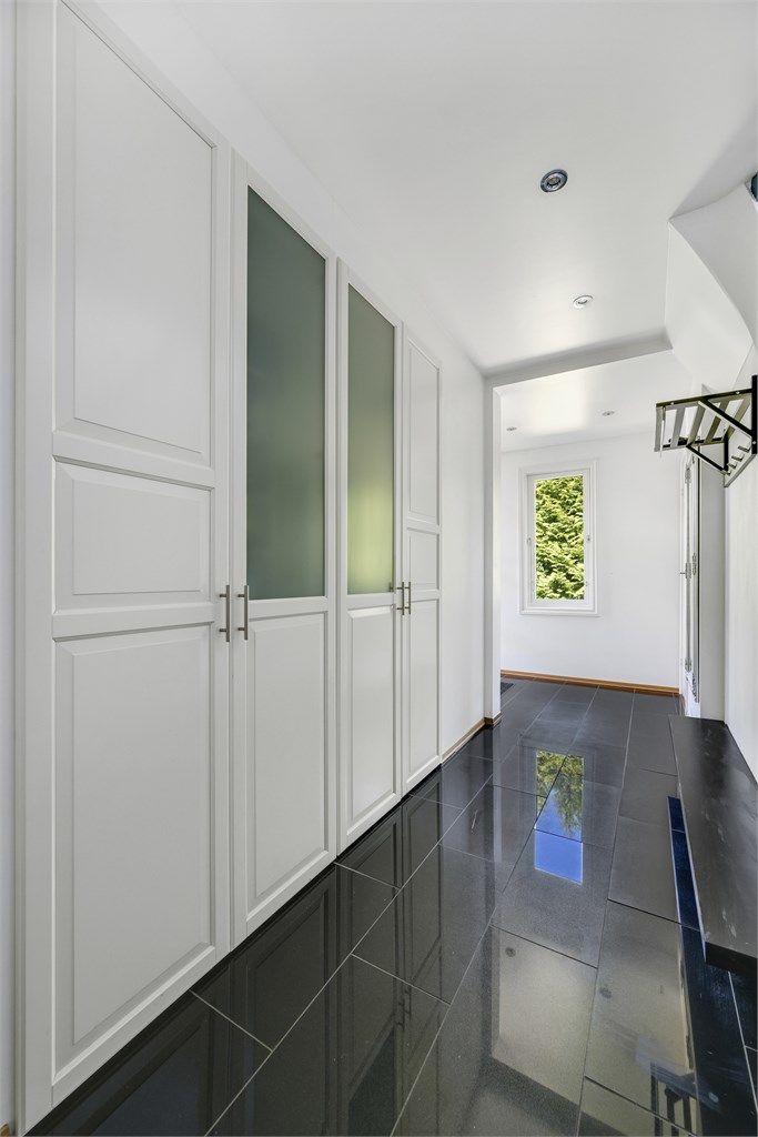 Du blir møtt av en stilren gang/entré med en stor og svært romslig innebygget garderobeløsning.