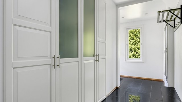 Du blir møtt av en stilren gang/entré med en stor og svært romslig innebygget garderobeløsning.