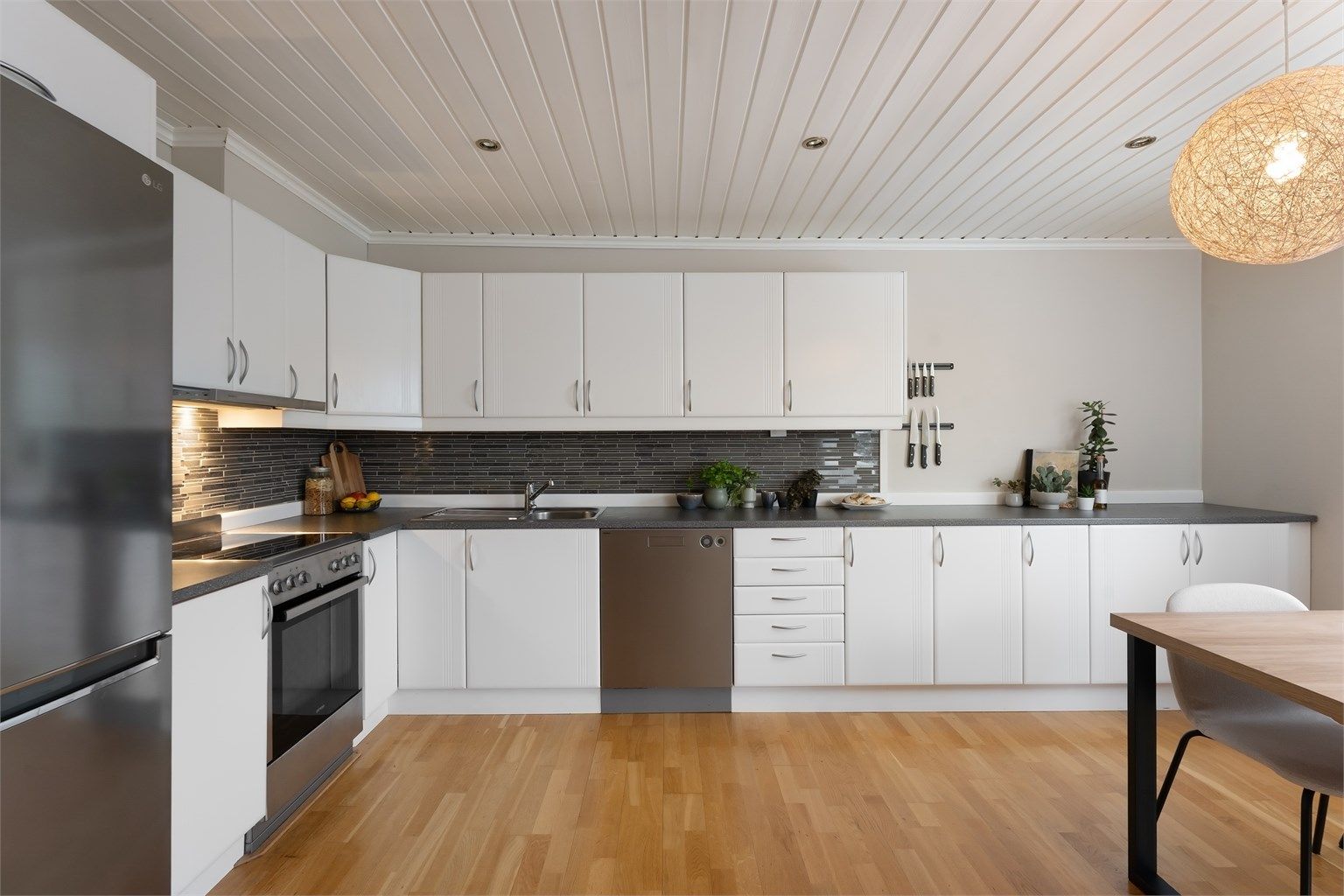 Romslig kjøkken med innredning med profilerte fronter og laminatbenkeplate.