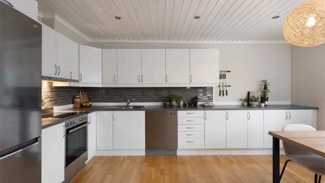 Romslig kjøkken med innredning med profilerte fronter og laminatbenkeplate.