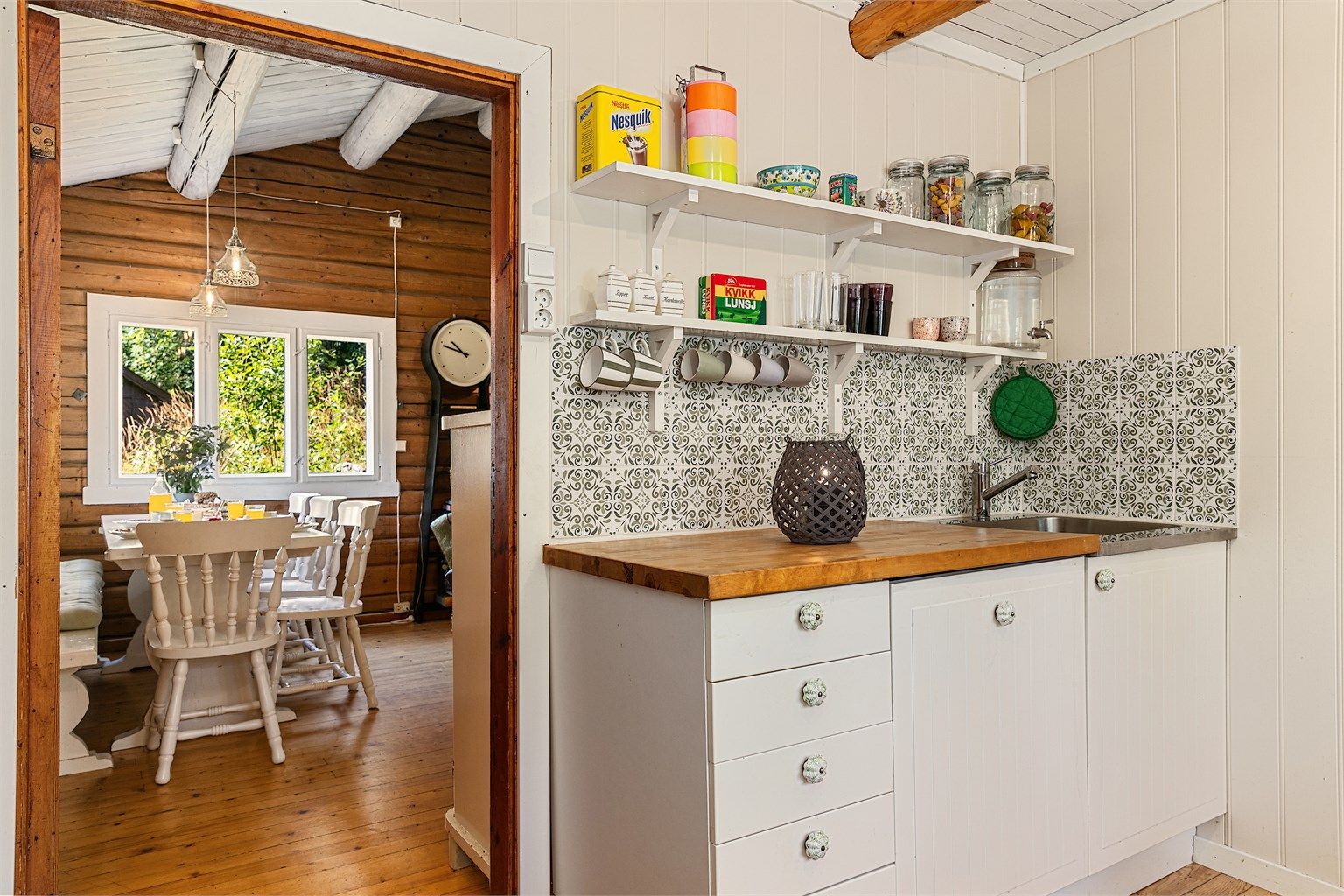 Rett utenfor kjøkkenet ligger en hyggelig spiseplass med vinduer som gir godt lys og fin utsikt til naturen