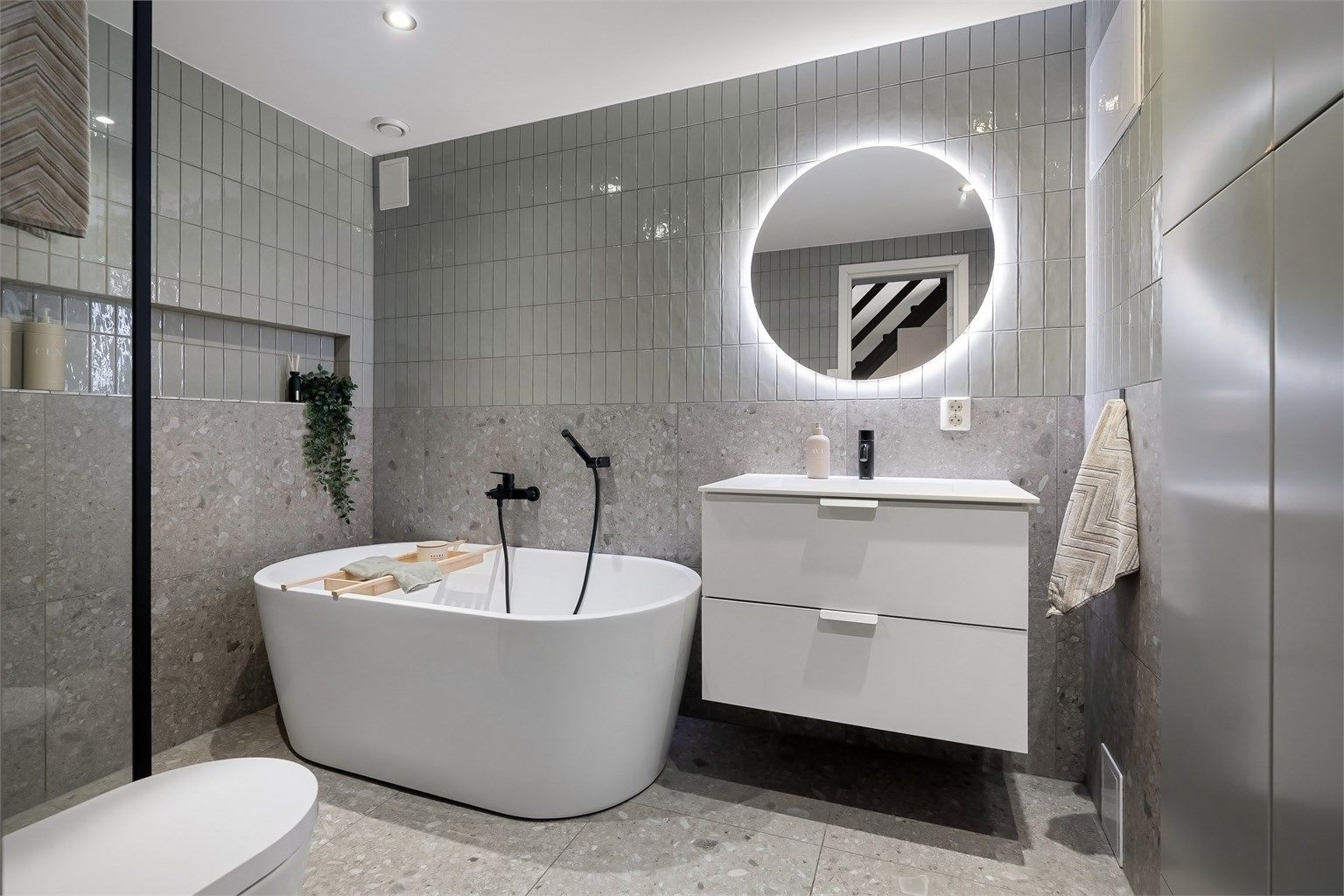 Delikat baderom fra 2021 med fliser på gulv med gulvvarme, fliser på vegger og malt himling med downlights