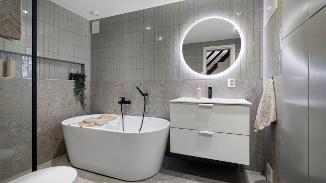 Delikat baderom fra 2021 med fliser på gulv med gulvvarme, fliser på vegger og malt himling med downlights