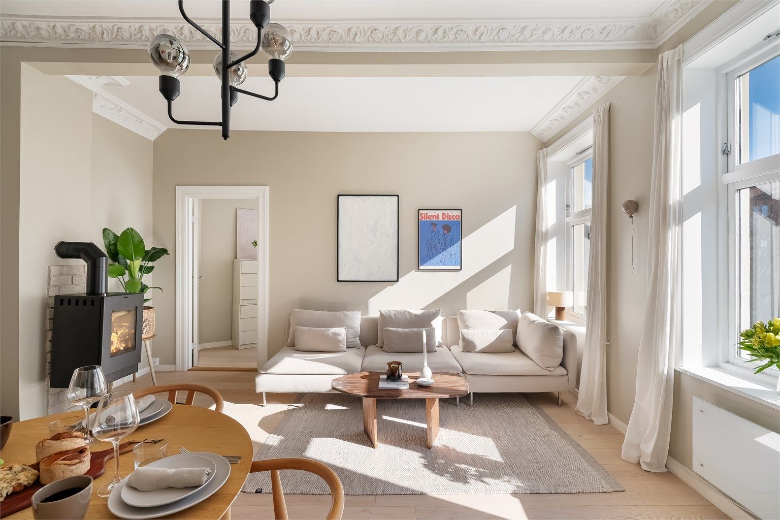 Her kommer det mye naturlig lys inn i leiligheten fra de store, klassiske vinduene.