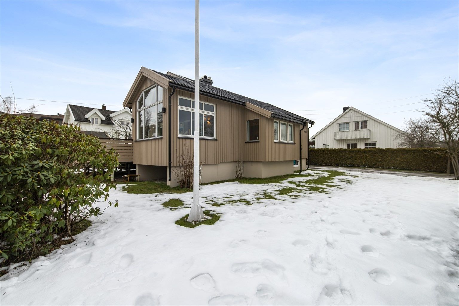 Tomten er pent opparbeidet med flott gressplen, prydbusker og fine blomsterbed.