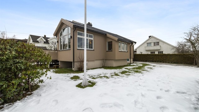 Tomten er pent opparbeidet med flott gressplen, prydbusker og fine blomsterbed.