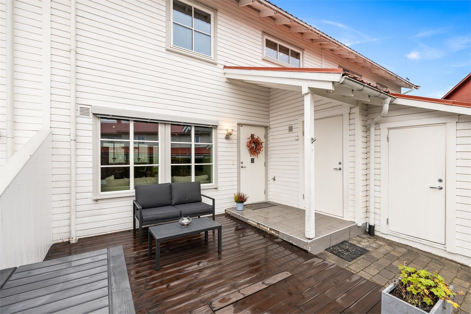 Den overbygde inngangen og terrassen på forsiden skaper en hyggelig velkomst.